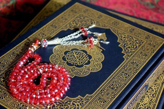 A book with a red beaded necklace on top of it